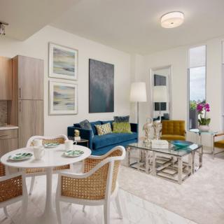 A modern living room with a cozy seating area and a small dining table.