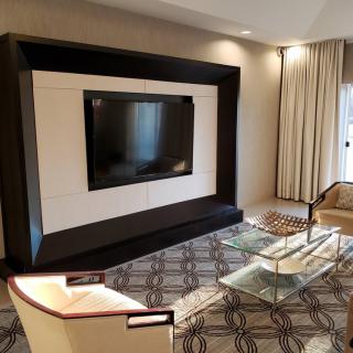 A modern living room with sleek furniture and a large TV setup.