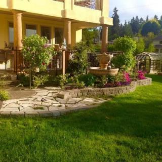 A beautiful garden with vibrant flowers and lush greenery outside a house.