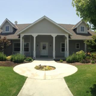 A charming suburban house with a well-maintained front yard and a paved pathway leading to the entrance.