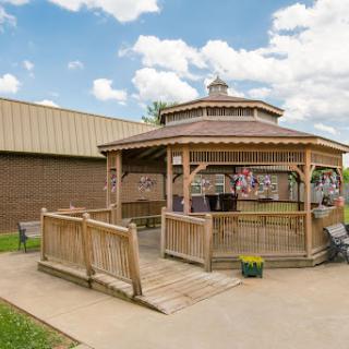 A beautiful wooden gazebo set in a peaceful outdoor environment, perfect for relaxation and gatherings.