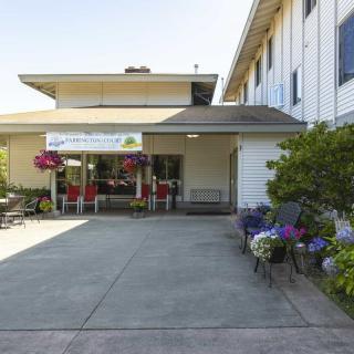 A building entrance adorned with flowers and a covered veranda.
