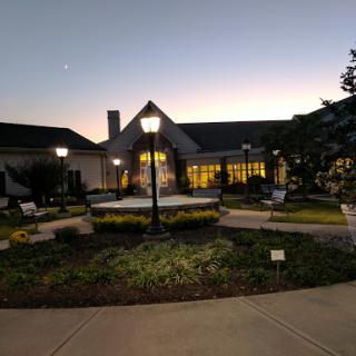 A serene evening view of a beautifully landscaped building surrounded by soft lighting.