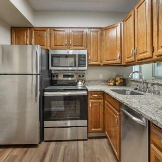 A modern kitchen with stainless steel appliances and wooden cabinets.