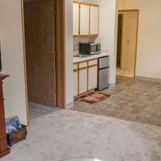 A small apartment kitchen with white cabinets and a microwave.