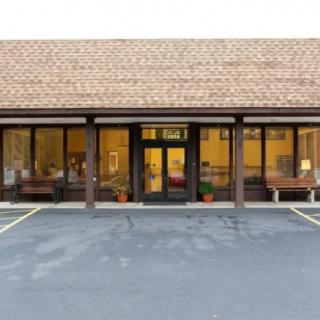 A storefront with large windows and an empty parking lot.