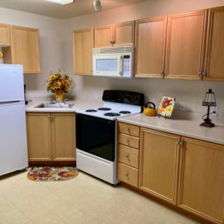 A well-organized kitchen with wooden cabinets, white appliances, and decorative accents.