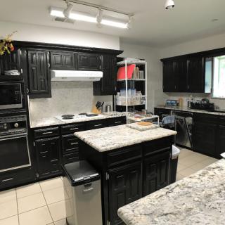 A modern kitchen with dark cabinets and granite countertops.