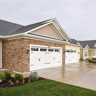 A suburban residential house with a double garage and brick facade.