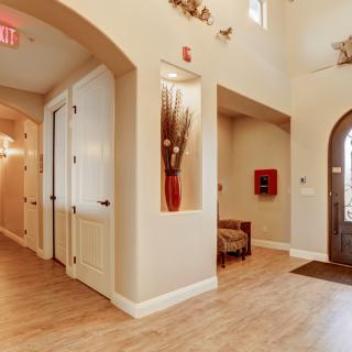 A modern hallway with elegant decor and artwork, leading to an entrance door.