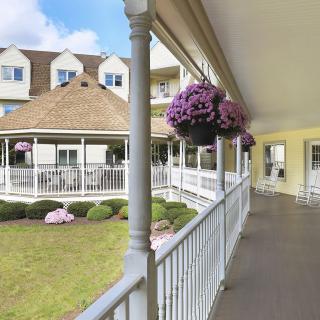 A charming veranda with hanging flower baskets overlooking a beautifully landscaped garden.