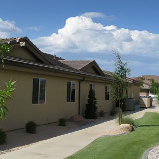 A suburban house with a well-maintained yard and clear skies.