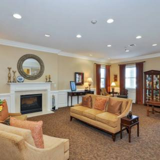 A traditional living room with a cozy fireplace, elegant sofas, and tasteful decor.