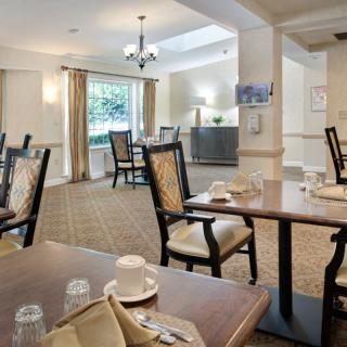 A well-lit dining area with neatly arranged tables and chairs, set against a tasteful interior design.