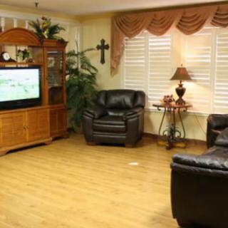 A cozy living room with leather seating and a television entertainment center.
