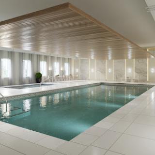 A serene indoor swimming pool featuring modern architecture and minimalist design.