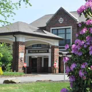 A health center surrounded by blooming flowers, showcasing a blend of nature and architecture.