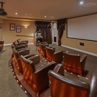 A cozy home theater with comfortable seating and a large projector screen.