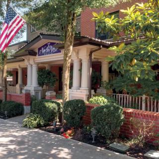 A charming restaurant with a brick exterior and an American flag displayed outside.
