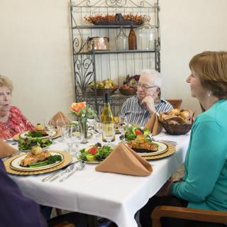 A group of people enjoying a meal together at a dining table indoors.