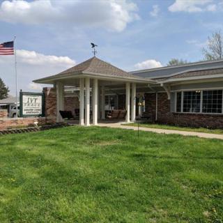 A building with a grassy lawn and an American flag in front.