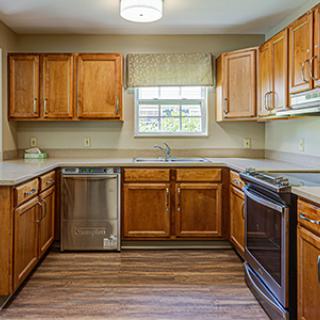 A traditional kitchen with wooden cabinets and modern appliances.