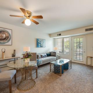 A cozy living room with a sofa, coffee table, dining area, and stylish dcor.