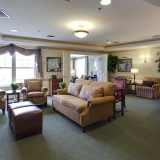 A comfortable and well-decorated living room area with sofas, chairs, and large windows.