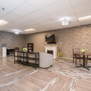 A modern lounge area featuring comfortable seating, a television mounted on a brick wall, and stylish decor.