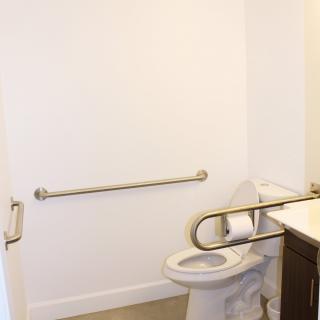 Accessible bathroom with safety grab bars installed.