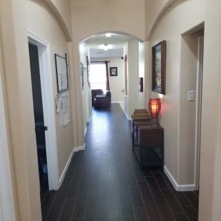 A well-lit hallway with dark wood flooring and decorative elements.