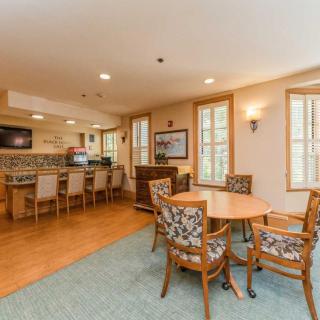 A cozy dining area with wooden furniture and a kitchen in the background.