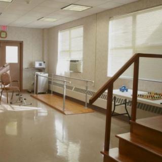 A rehabilitation room equipped with parallel bars and stairs for physical therapy exercises.