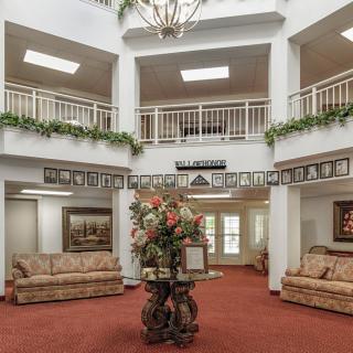 Spacious lobby with elegant furnishings and a central floral arrangement.