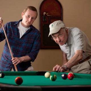 Two individuals playing billiards together.