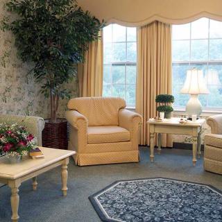 A cozy living room with beige armchairs, a coffee table, and warm lighting.