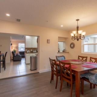 A cozy dining room with wooden furniture, adjacent to a kitchen and living area.