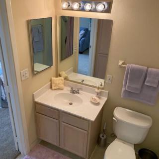 A small bathroom with a sink, mirror, and toilet.