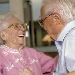 An elderly couple sharing a joyful moment together indoors.