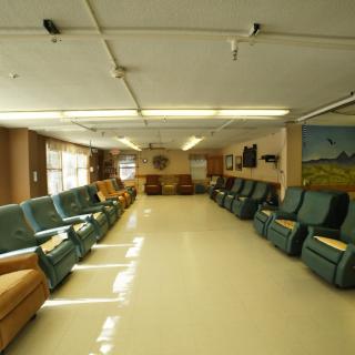 A spacious lounge area with rows of comfortable chairs and ample natural light.