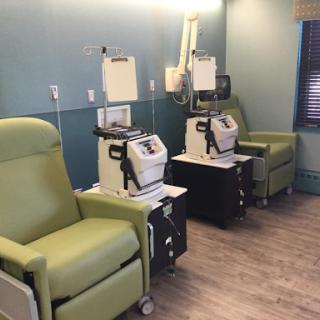 A treatment room featuring comfortable infusion chairs and medical equipment for patient care.