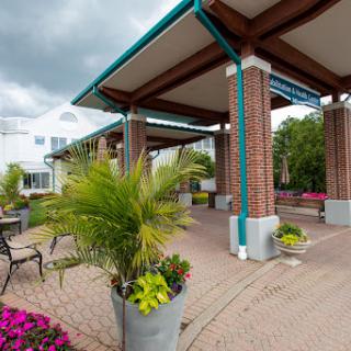 A serene outdoor space featuring a modern architectural structure surrounded by vibrant flowers and lush greenery.