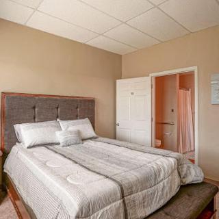 A cozy and neutral-toned bedroom featuring a double bed and simple decor.