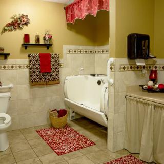 A traditional bathroom with red decorative accents and a tiled floor.