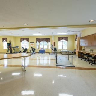 A spacious rehabilitation center equipped with various exercise and physical therapy equipment.