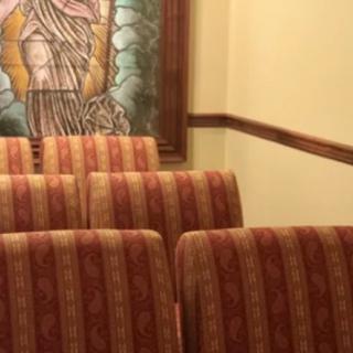 A row of upholstered chairs in front of a wall featuring a large framed painting.