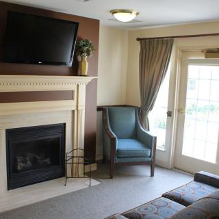 A cozy living room with a fireplace, television, and comfortable seating.