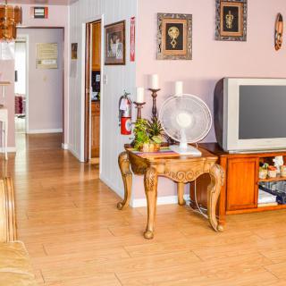 A cozy living room with vintage decor, featuring a wooden floor and a classic television set.