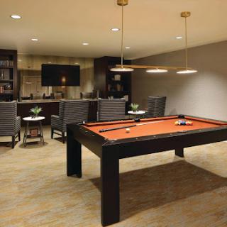 A stylish game room featuring a pool table and comfortable seating.