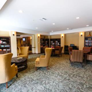 A cozy lounge area with armchairs and bookshelves.